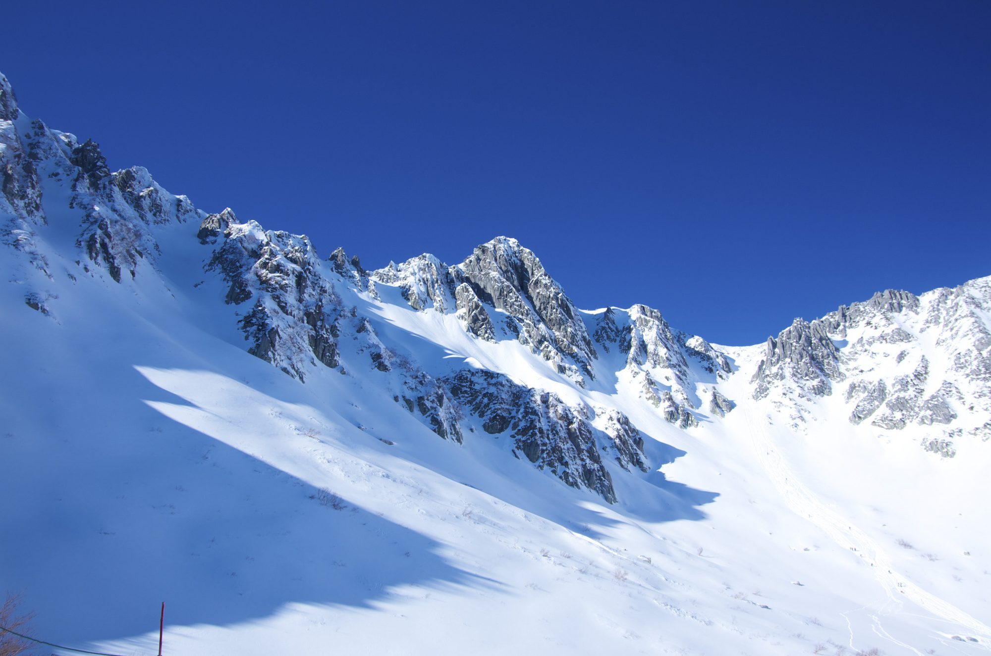 Snow-covered mountain ridge under a clear blue sky