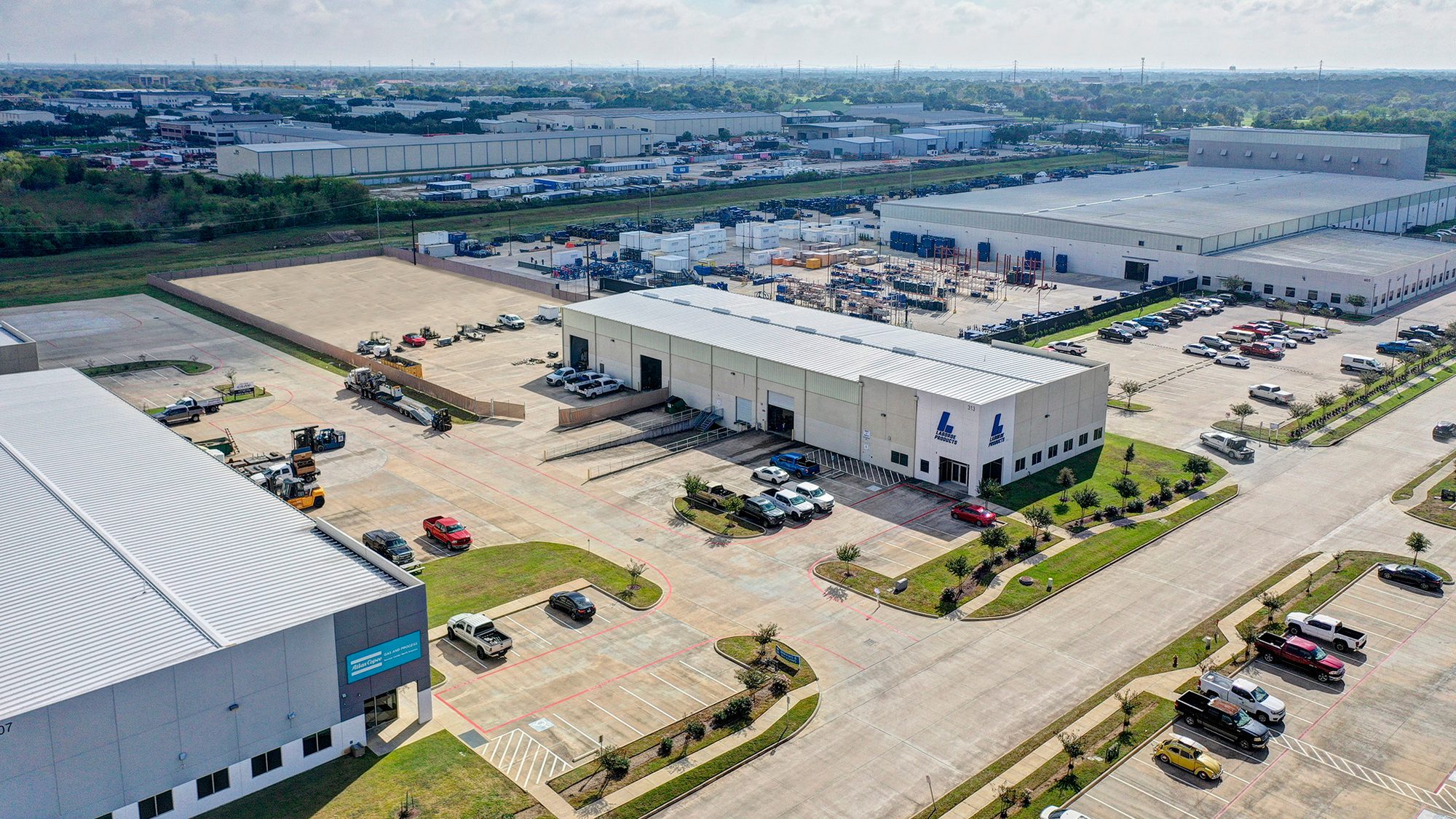 Aerial view of the industrial building and paved storage yard at 313 Deerwood Glen Drive, Deer Park, Texas